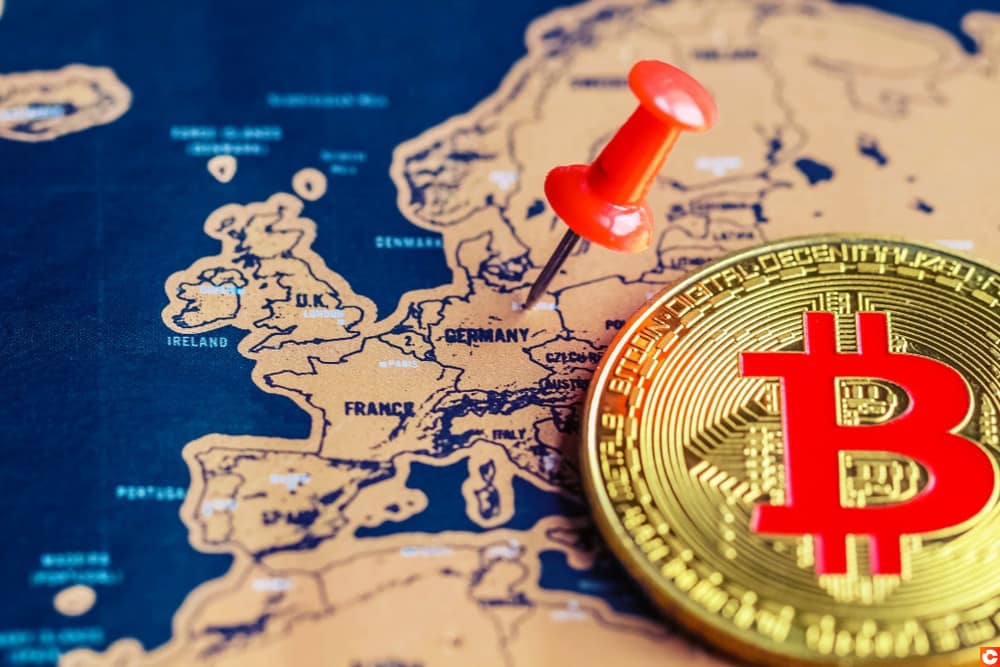 Un bitcoin posé sur une carte de l'Europe