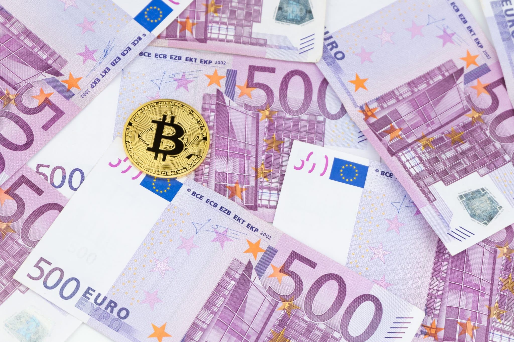 Golden bitcoin on pile of five hundred euro banknotes background. Cryptocurrency, digital currency with euro money bills. Bitcoin exchange and accepted to payment, Finance and technology concept.
