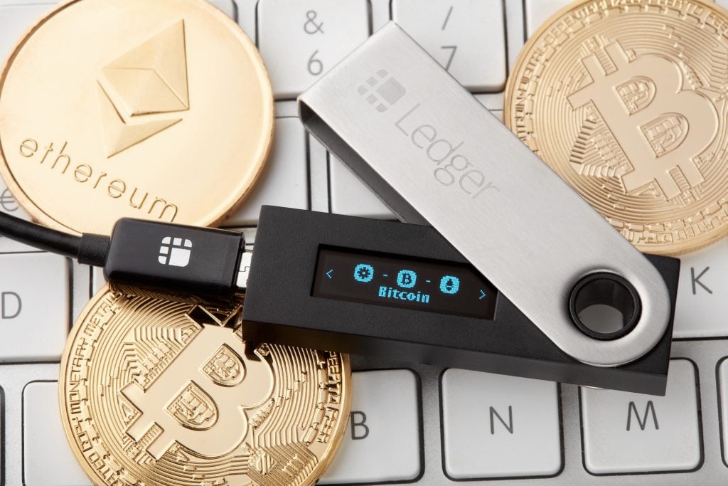 Ledger hardware wallet for cryptocurrency with golden bitcoin and ethereum