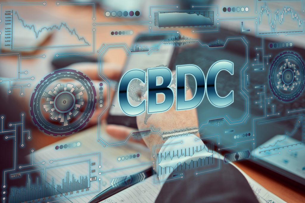 A young businessman uses a futuristic smartphone with the latest holographic technology of augmented reality with the inscription "CBDC". Central bank digital currency concept