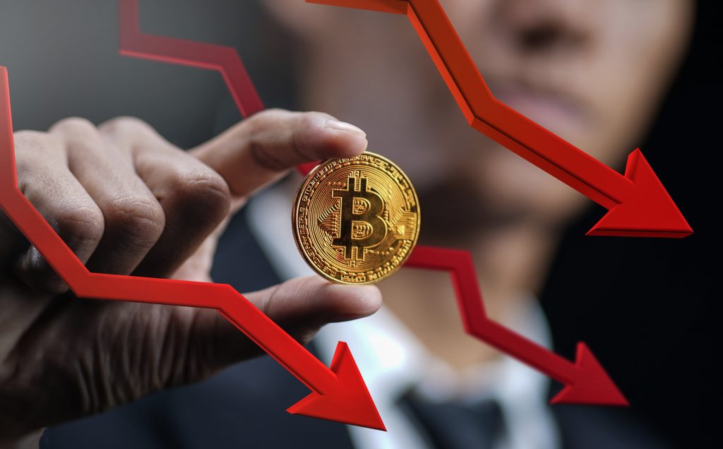 Bitcoin Price Falling Down. Businessman Holding Bitcoin With Red 3D Arrow Down
