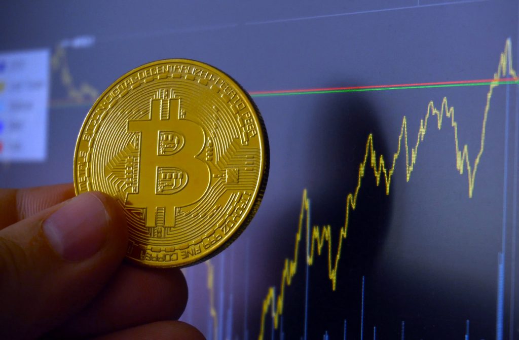 Digital currency of future Bitcoin. Golden BTC coin in front of charts