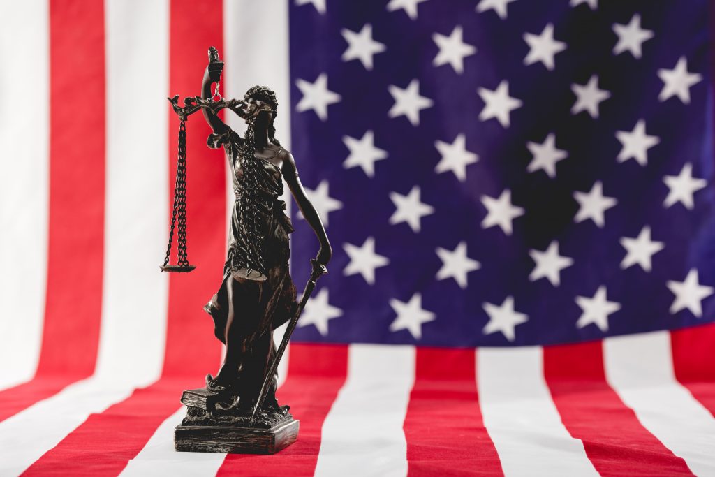 selective focus of justice statue near american flag
