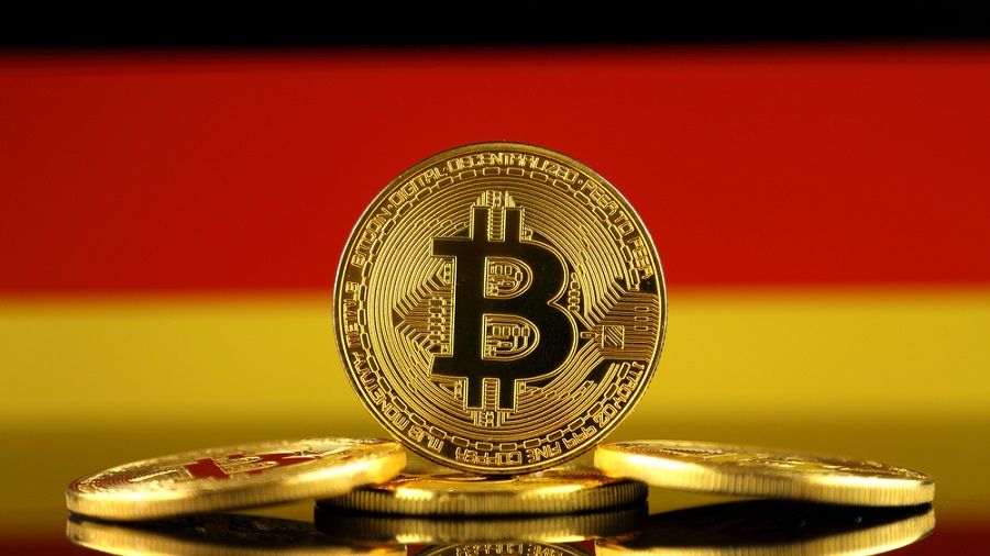 Des pièces de bitcoin (BTC) posées devant le drapeau de l'Allemagne