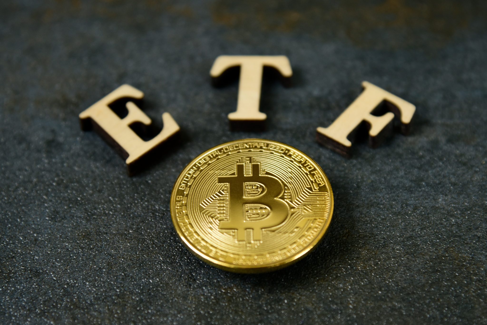 Bitcoin coin with ETF text on stone background