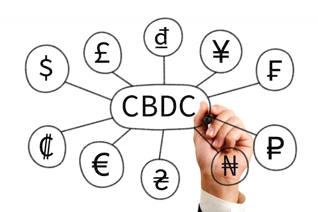 cbdc. a man draws the inscription cbdc and icons of currencies of different states