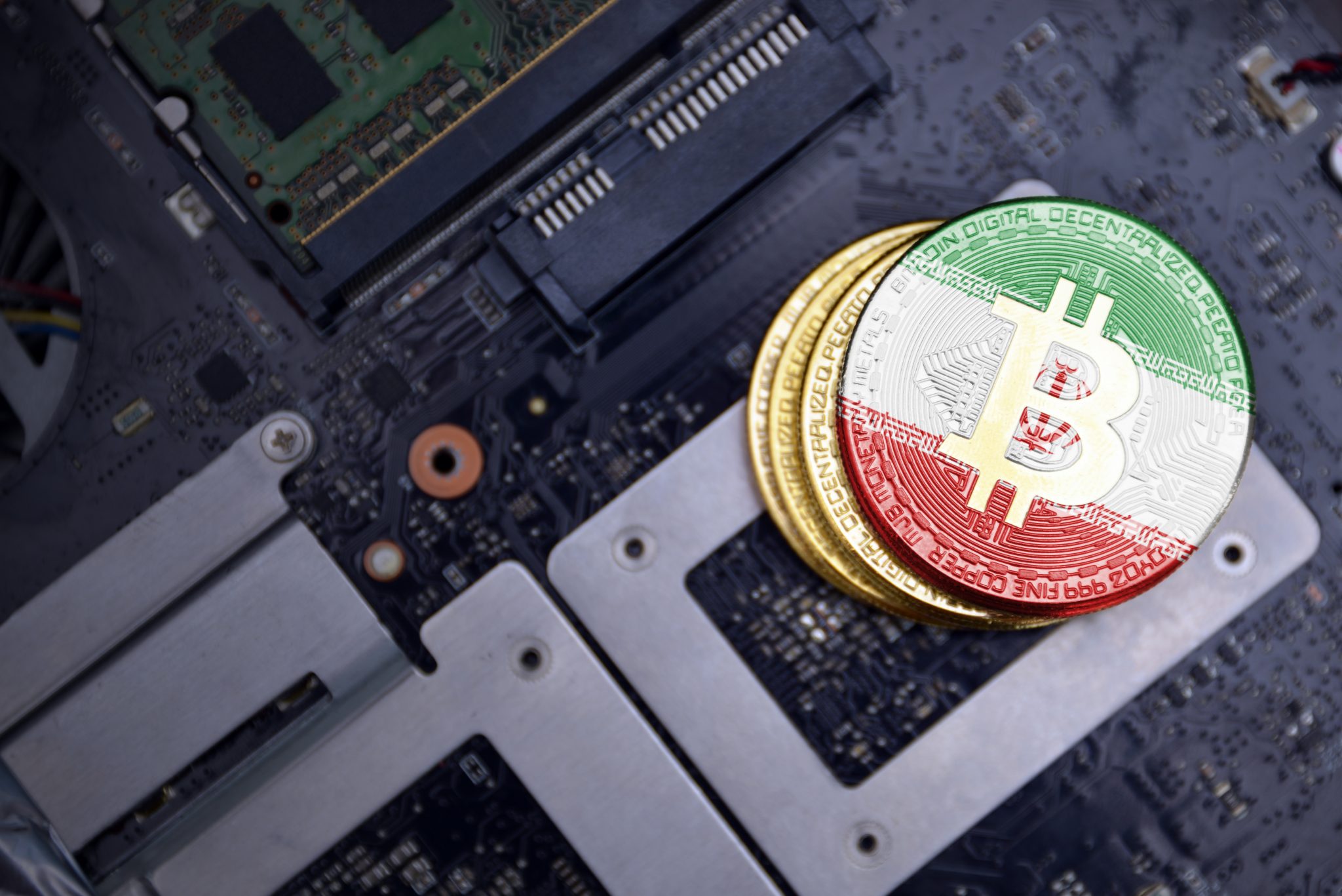 golden bitcoins with flag of iran on a computer electronic circuit board. bitcoin mining concept.