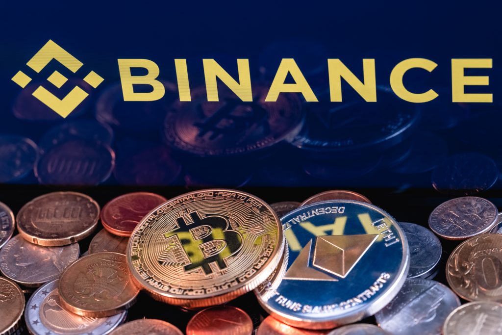 Kazan, Russia - May 17, 2021: Binance is cryptocurrency exchange that provides a platform for trading various cryptocurrencies. Ethereum coin and Bitcoin on the background of the BINANCE inscription.