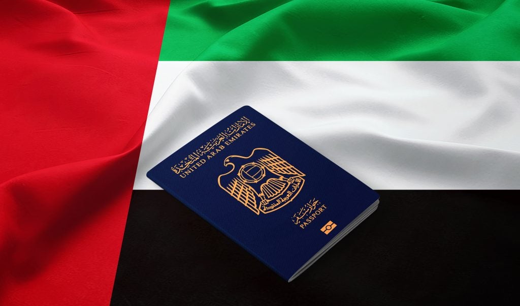 Passport of United Arab Emirates on the top of an  flag of emirates