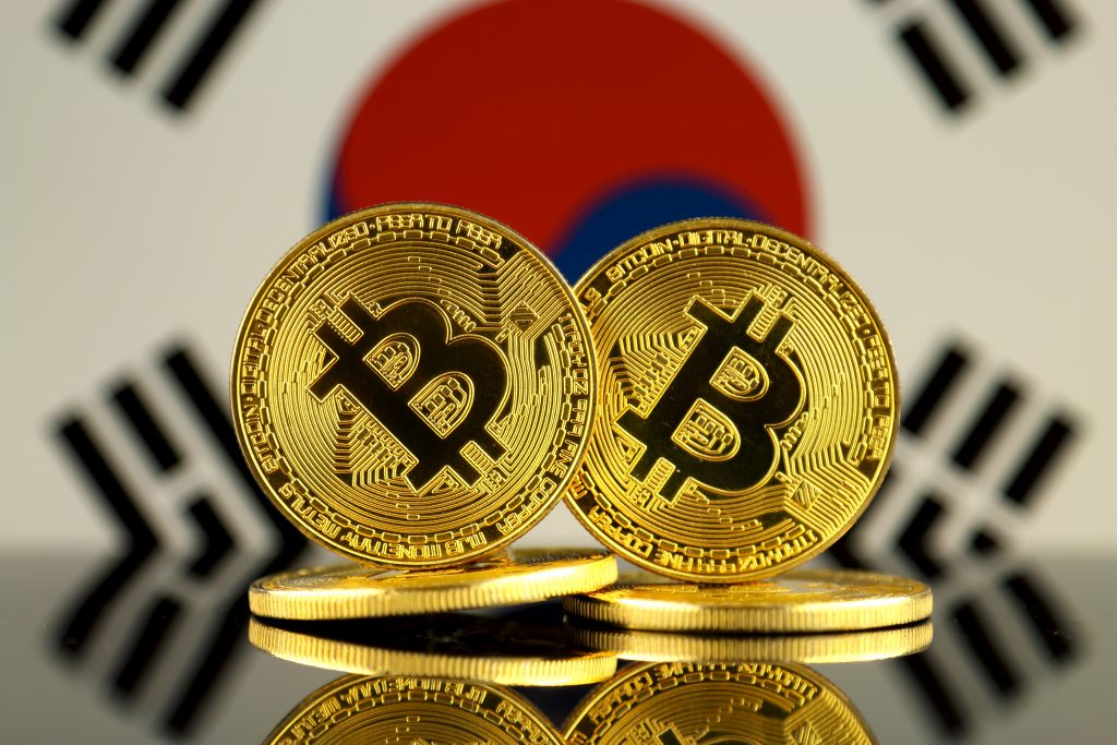 Physical version of Bitcoin and South Korea Flag. Close up.