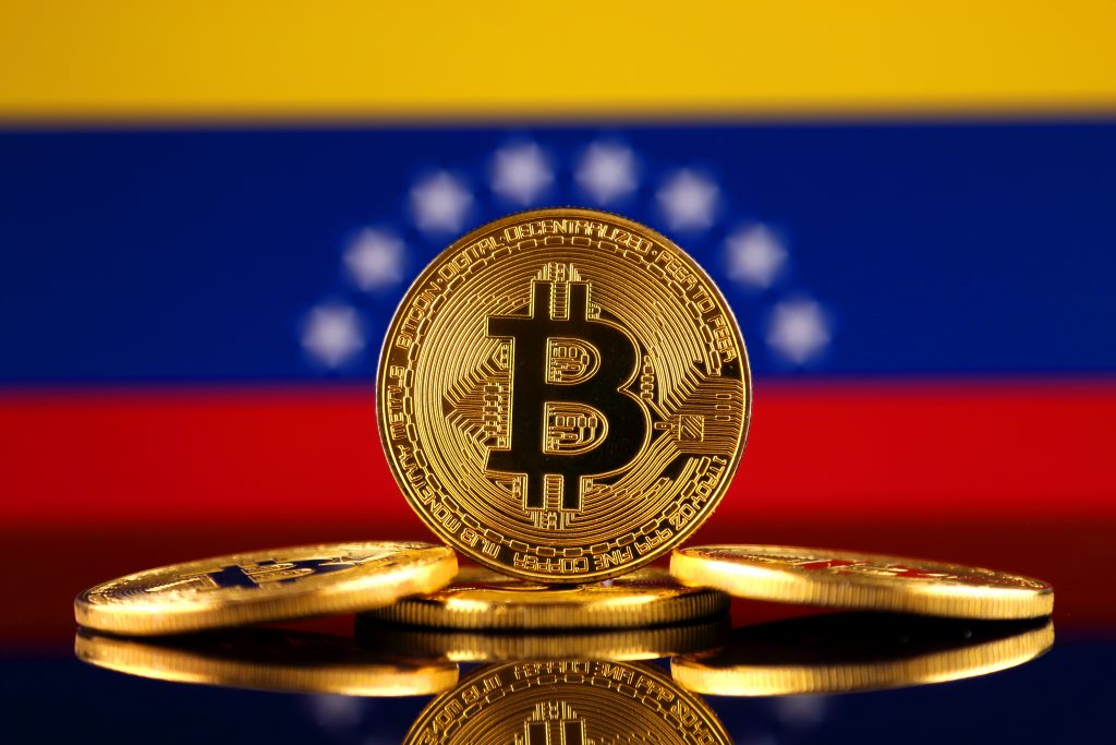 Physical version of Bitcoin (new virtual money) and Venezuela Flag. Conceptual image for investors in cryptocurrency and Blockchain Technology in Venezuela.