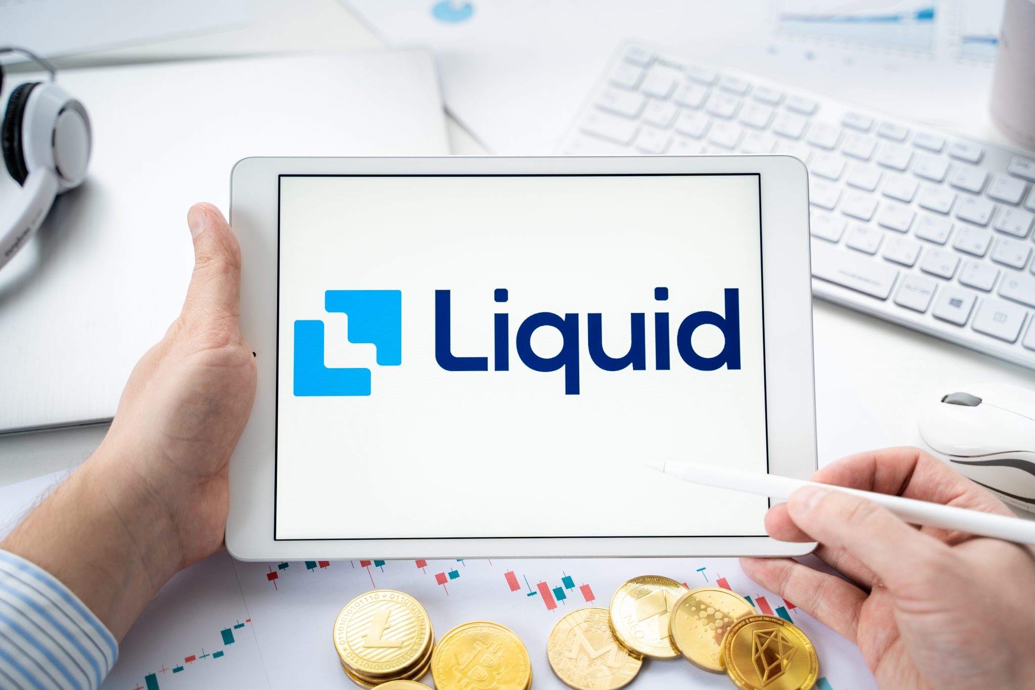 Russia Moscow 06.05.2021.Businessman with tablet.Logo of cryptocurrency stock exchange Liquid.Trading blockchain platform to buy,sell digital crypto coins,tokens Bitcoin,Ethereum.Business,investing.