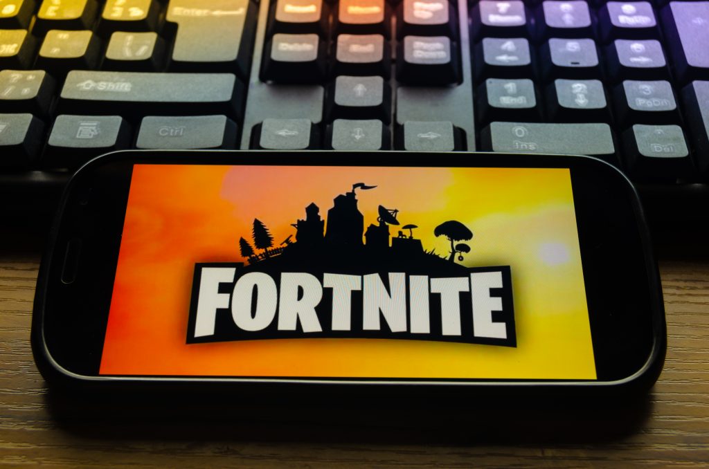 Kostanay, Kazakhstan, January 29, 2019.Mobile phone on the keyboard background, with the logo of the popular game Fortnite from Epic Games.
