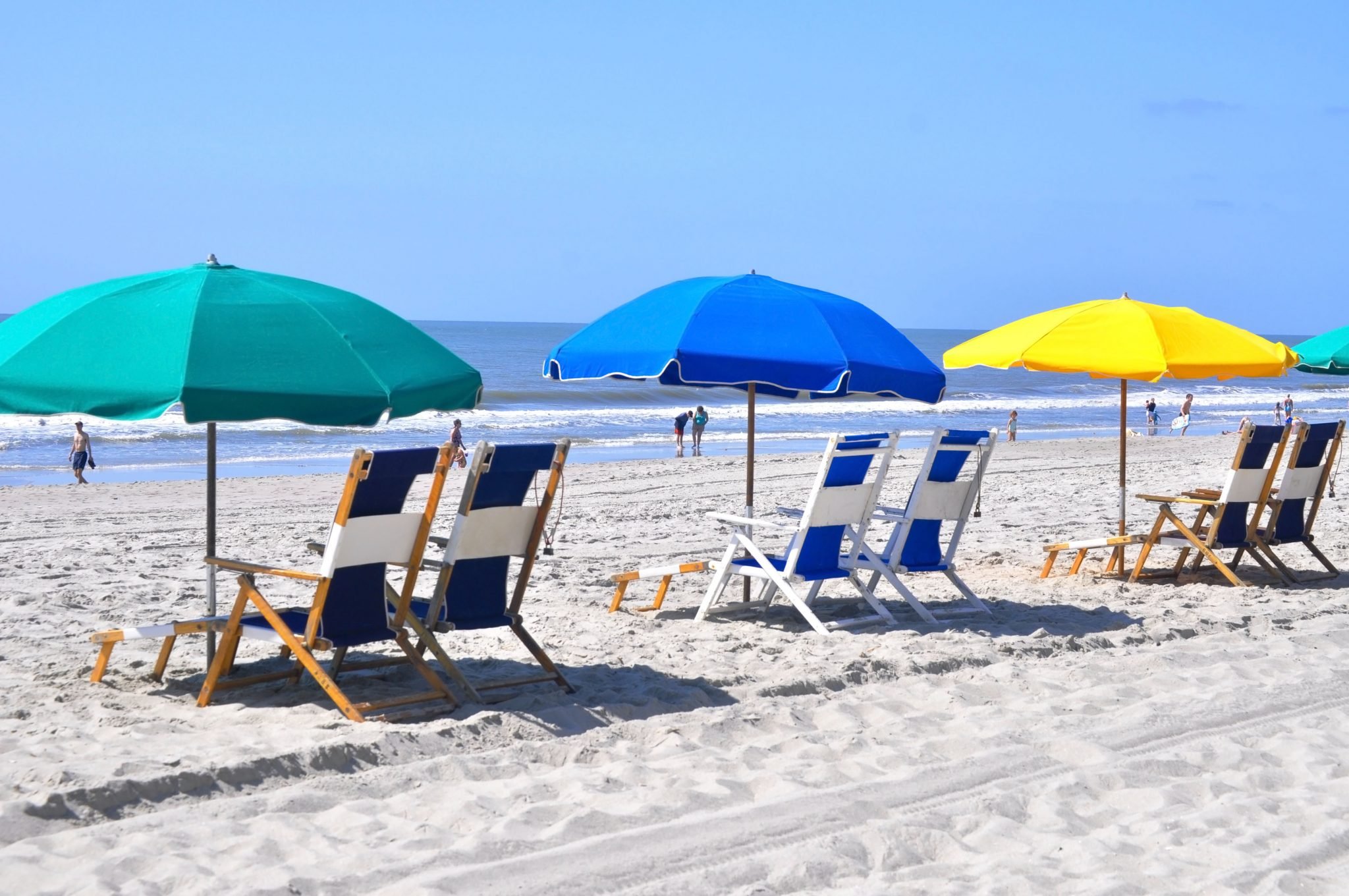 Beach chairs with Umbrellas on beach.