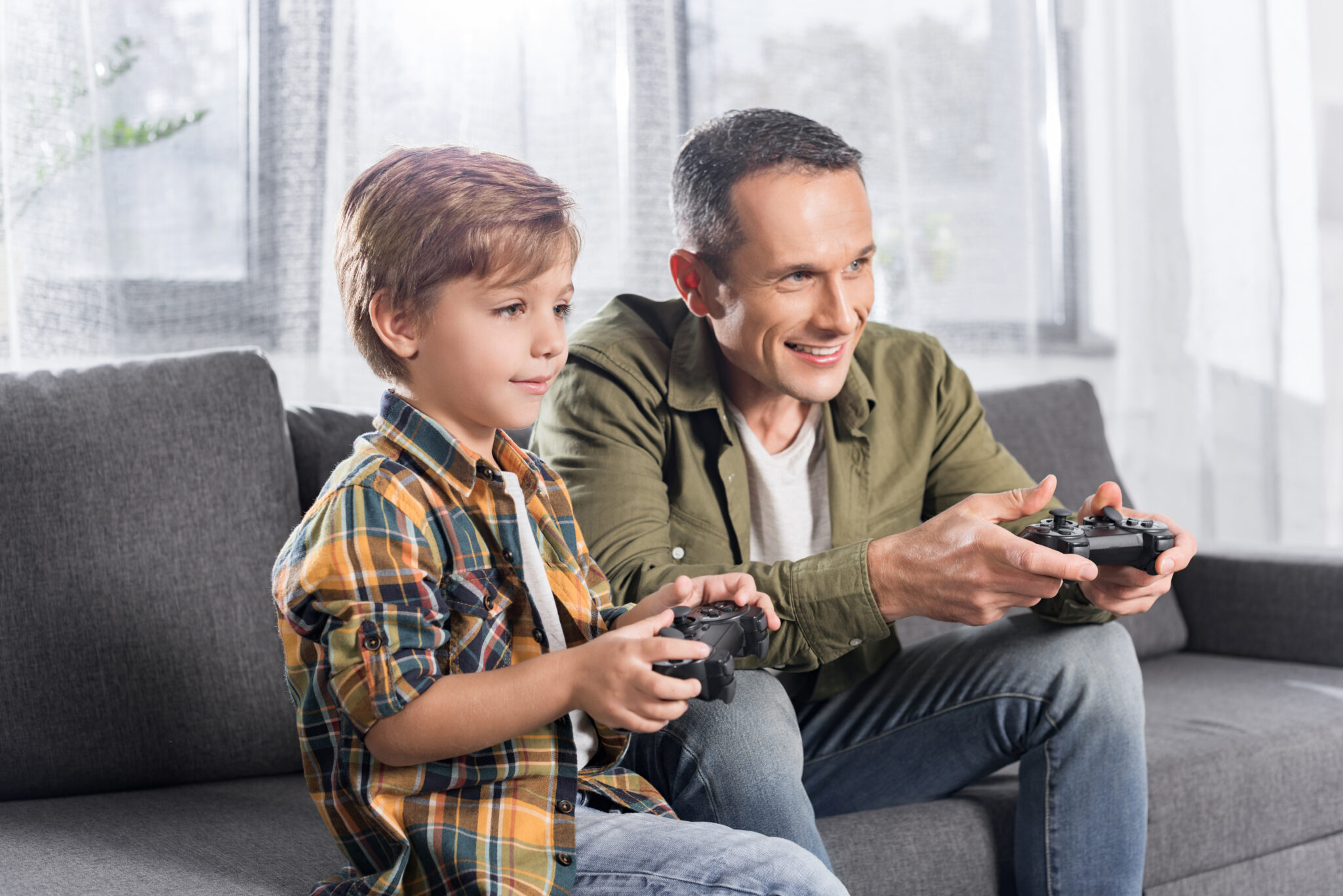 father and son playing console with gamepads