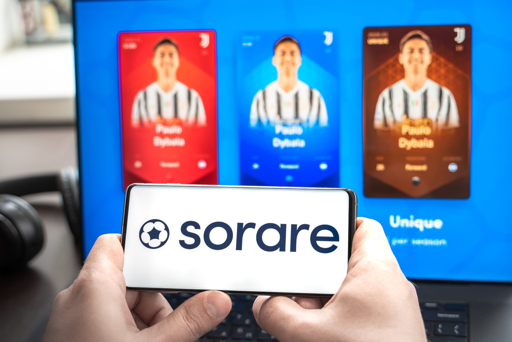 Russia Moscow 30.05.2021.Logo,screenshot of blockchain nft ethereum cryptocurrency sport football, soccer game Sorare in laptop,mobile phone.Man playing,collecting cards Earning digital money at home.