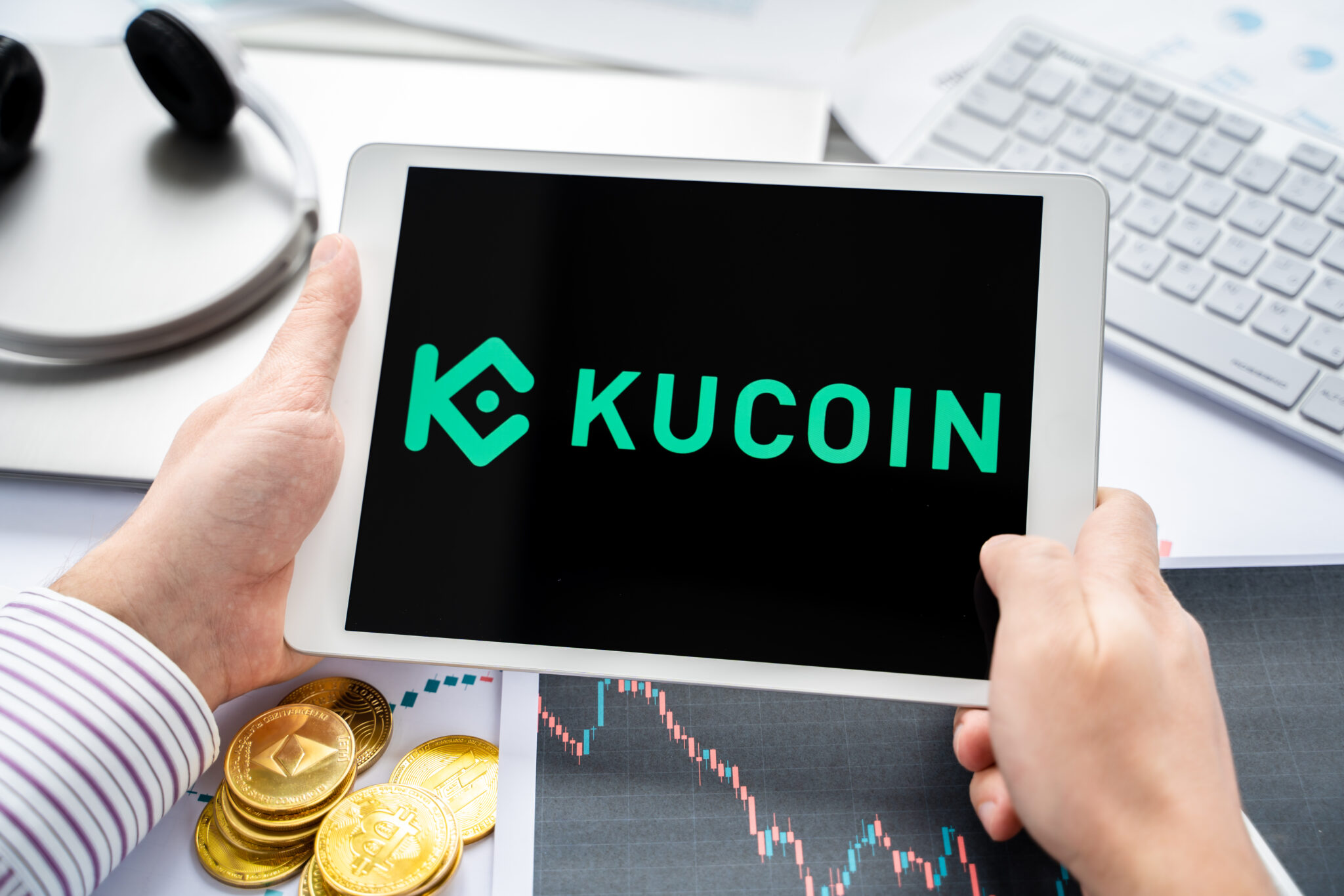 Russia Moscow 05.05.2021. Tablet with logo of cryptocurrency stock exchange Kucoin, China. Crypto coins company, service for buying, selling, trading, investing by market price. Bitcoin, Ethereum.