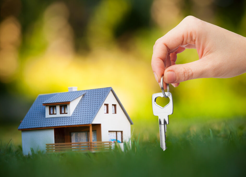 hand holding key against house background