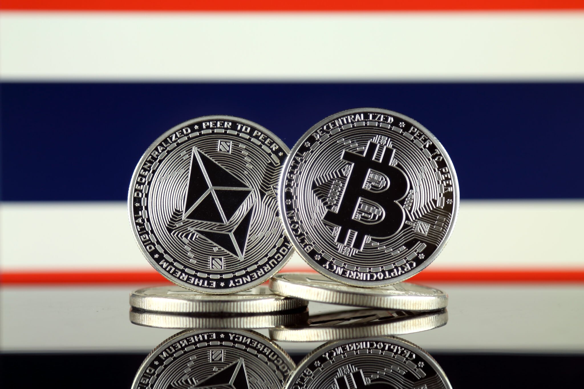 Physical version of Ethereum (ETH), Bitcoin (BTC) and Thailand Flag. 2 largest cryptocurrencies in terms of market capitalization.