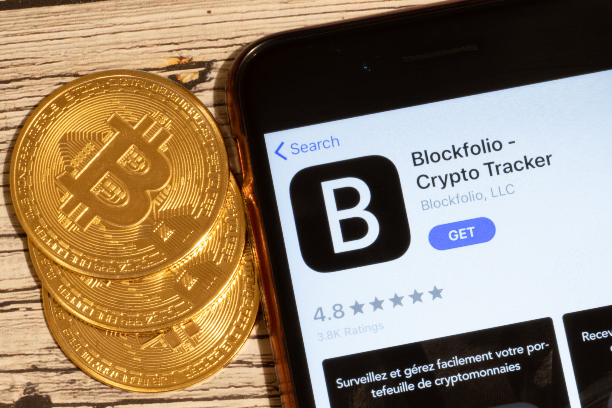 Saint-Petersburg, Russia - 10 January 2020: Phone screen with Blockfolio Crypto Tracker mobile app logo close up with bitcoin coins, Illustrative Editorial