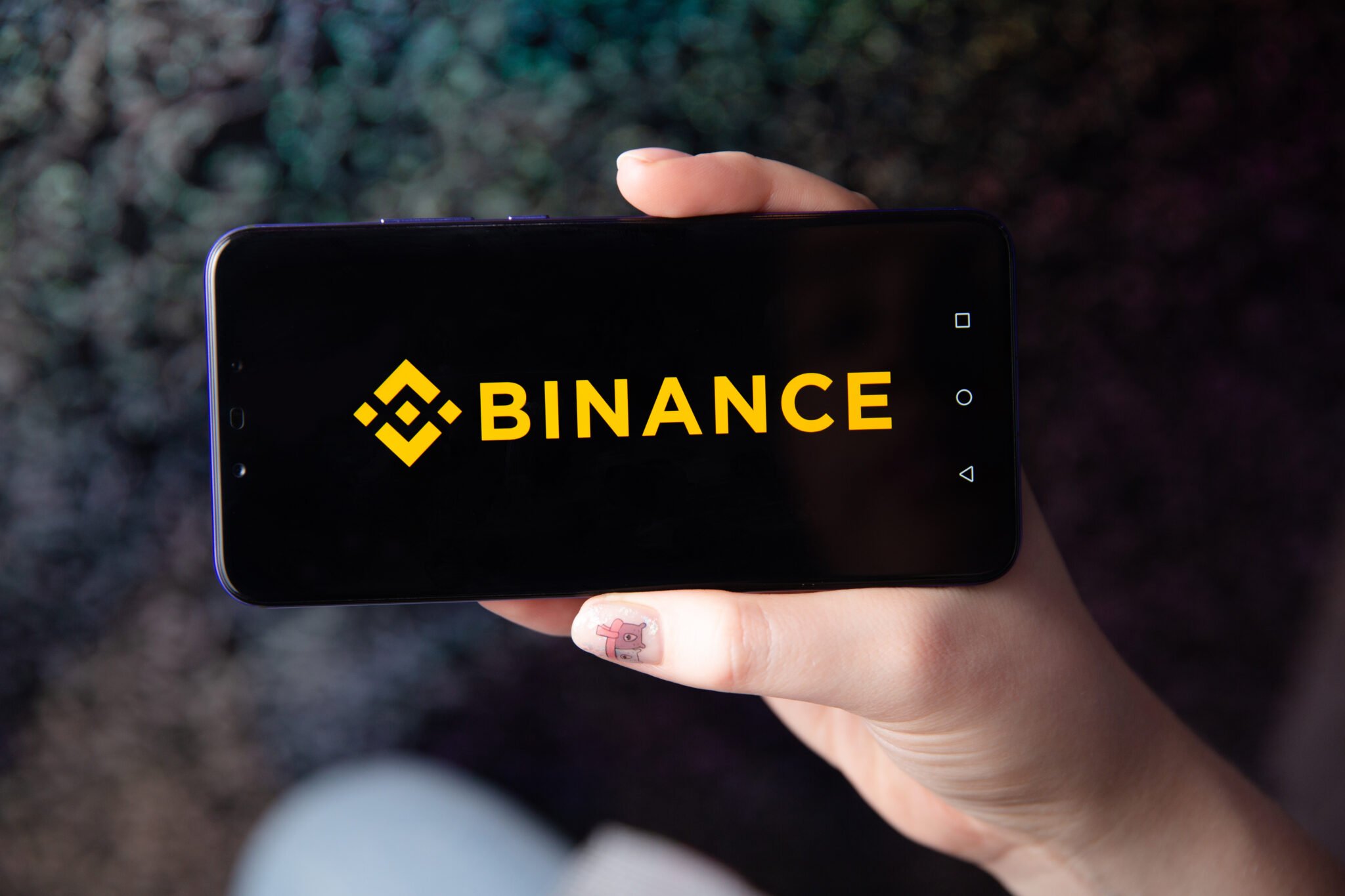 Tula, Russia - November 28, 2018: Apple iPhone and Binance logo and bitcoin, ethereum and dollars. is a cryptocurrency exchange.