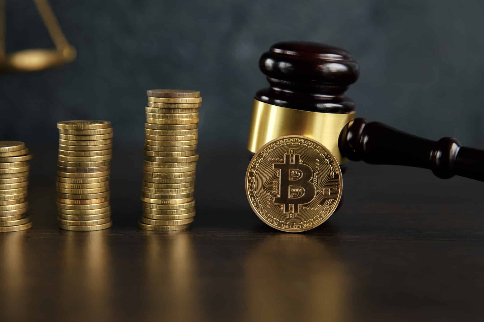 Auction gavel and bitcoin cryptocurrency money on a wooden desk, close-up. Law Gavel and golden bitcoin symbol on white background with