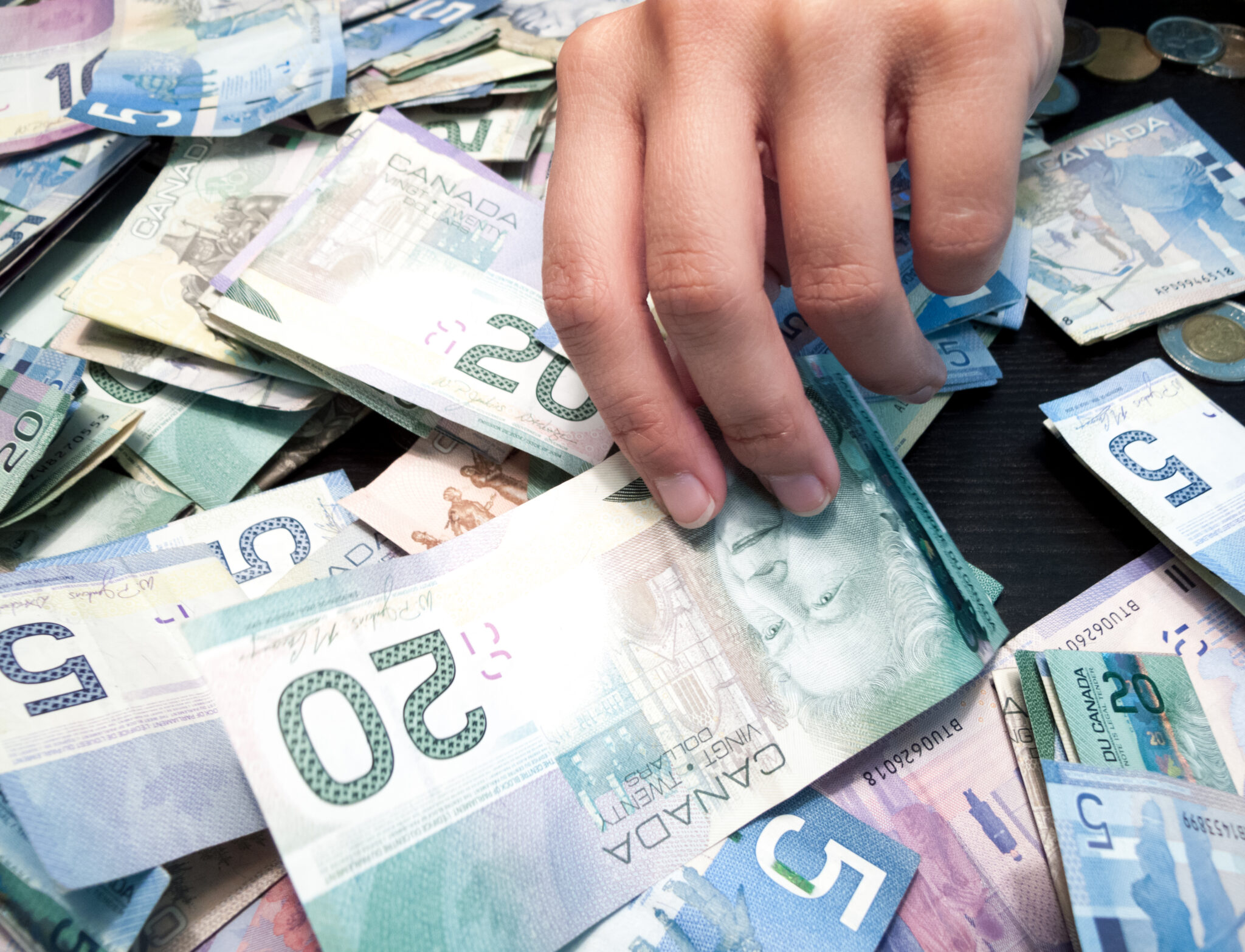 Hand picking Twenty Canadian Dollar Bill