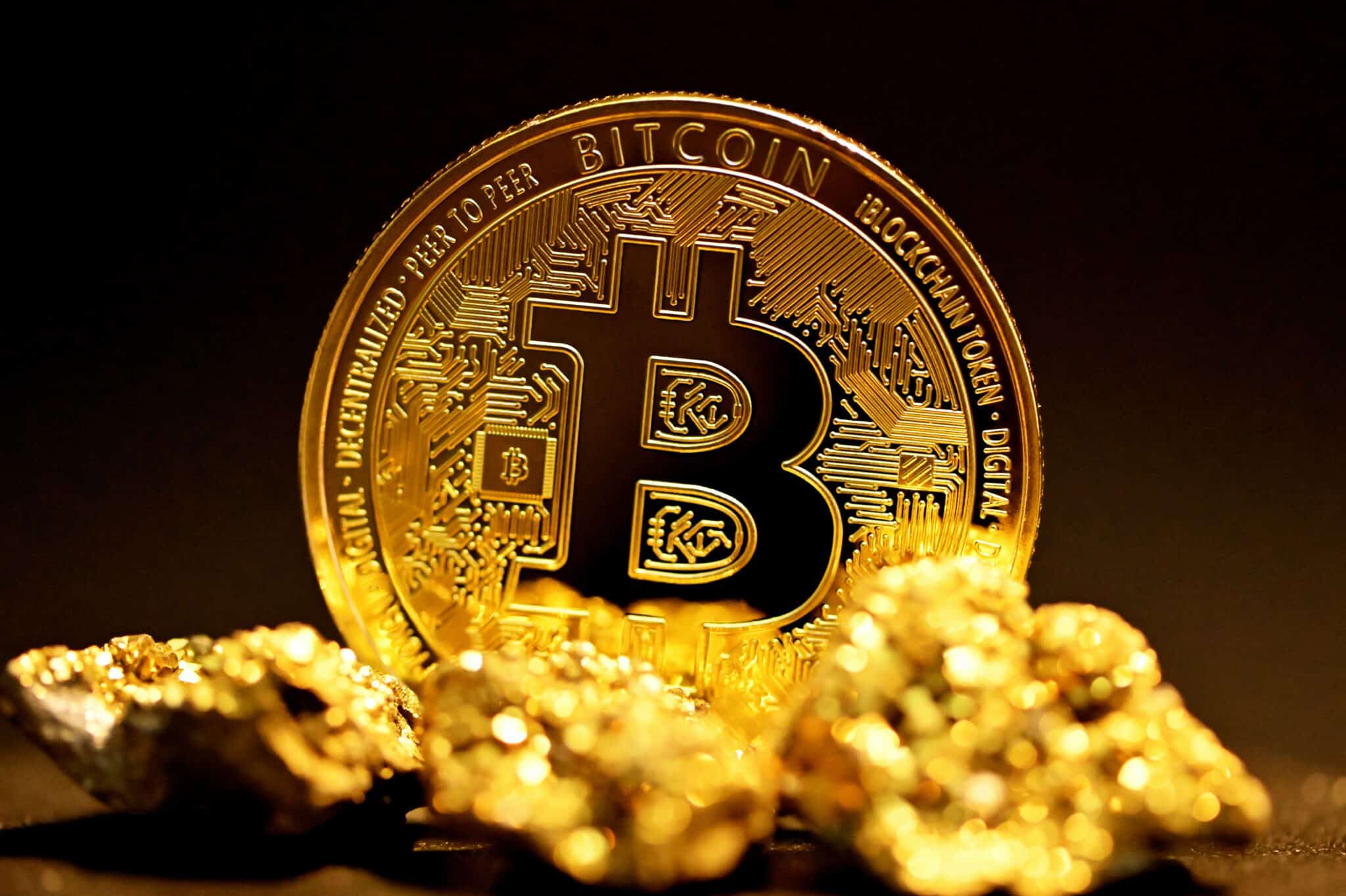 A single bitcoin surrounded by raw gold coins.