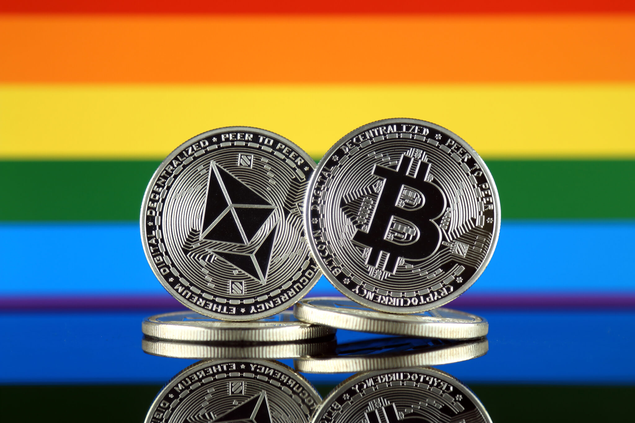 Physical version of Ethereum (ETH), Bitcoin (BTC) and Rainbow Flag. 2 largest cryptocurrencies in terms of market capitalization.