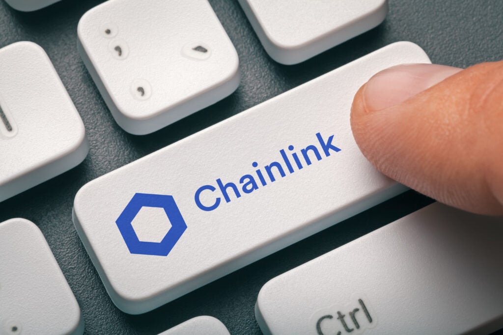 Cryptocurrency trading concept: Male hand pressing computer key with Chainlink/Link logo. Cryptocurrency mining, trading, market concept.