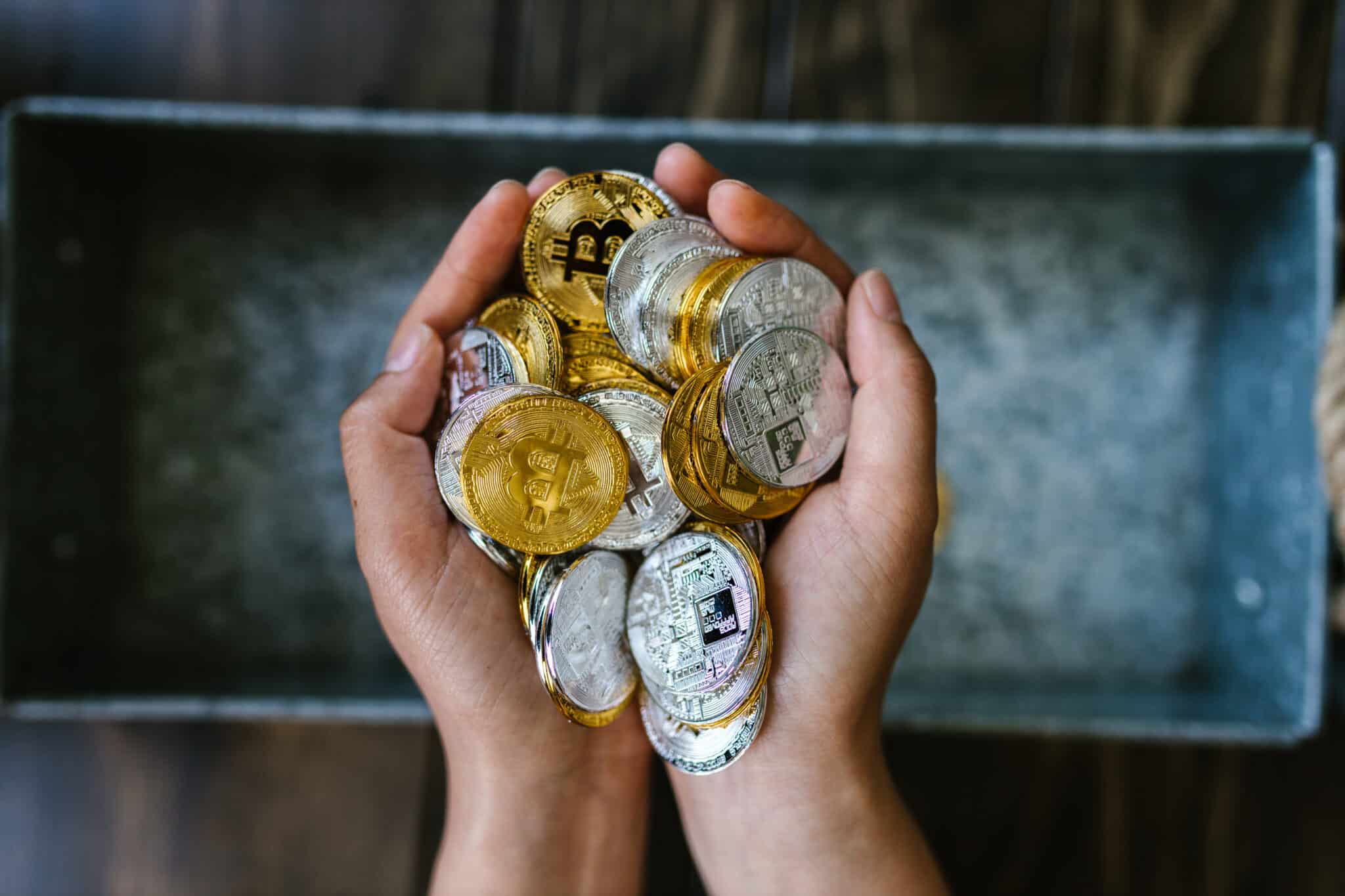 Person holding round gold and silver coins
