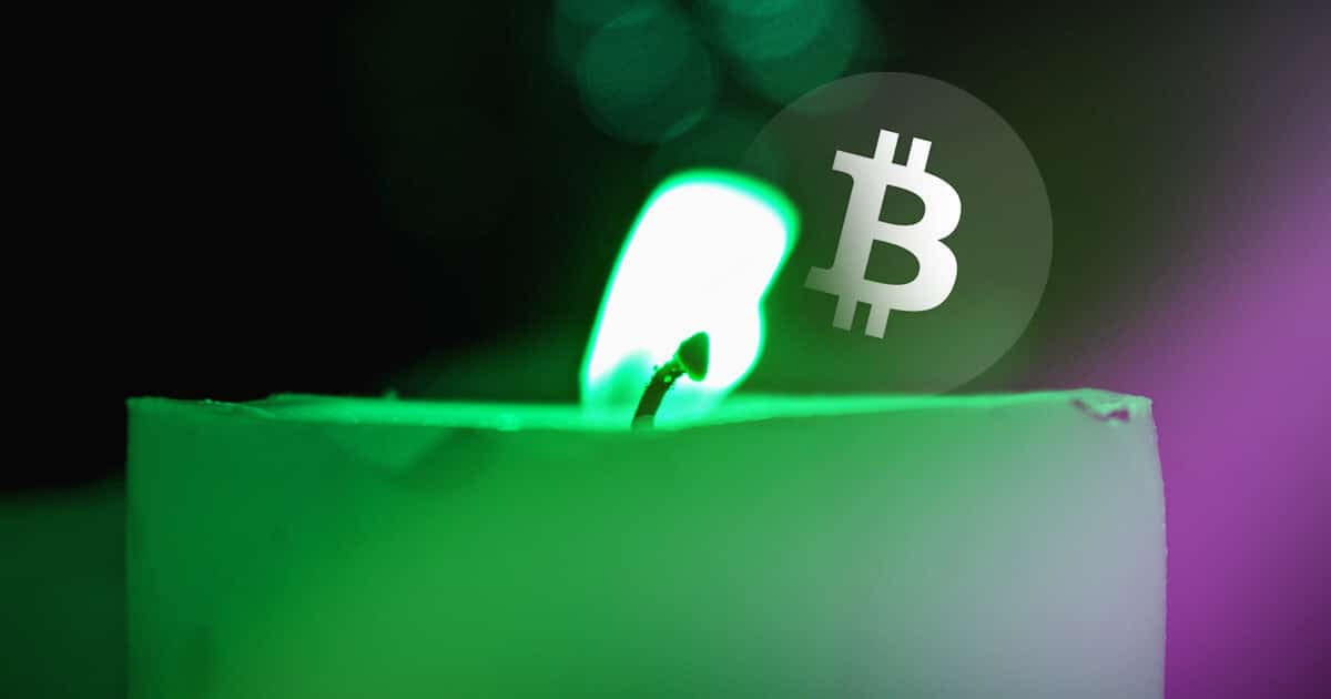Une bougie verte qui brûle avec le logo du bitcoin en arrière plan.