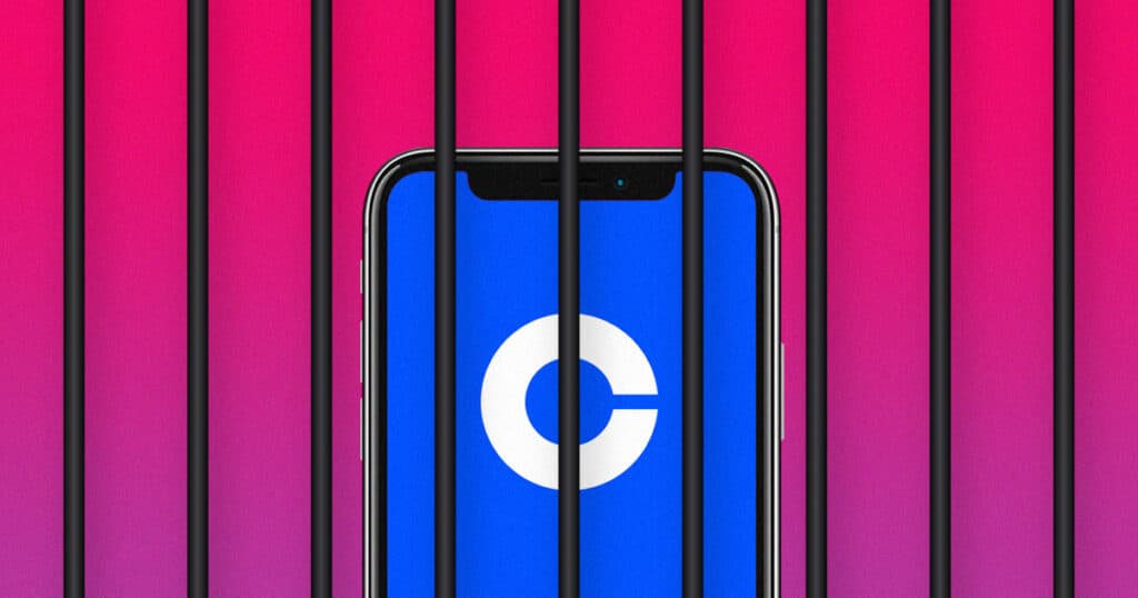 Un téléphone affichant le logo de Coinbase est derrière des barreaux de prison