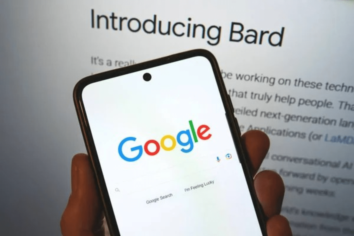 Une personne tenant un smartphone avec l'application Google Search avec en fond Google Bard.