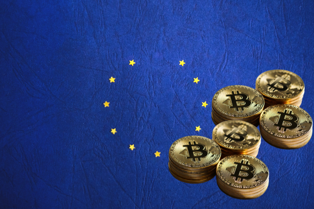 Le drapeau de l'Union Européenne et des pièces de bitcoin