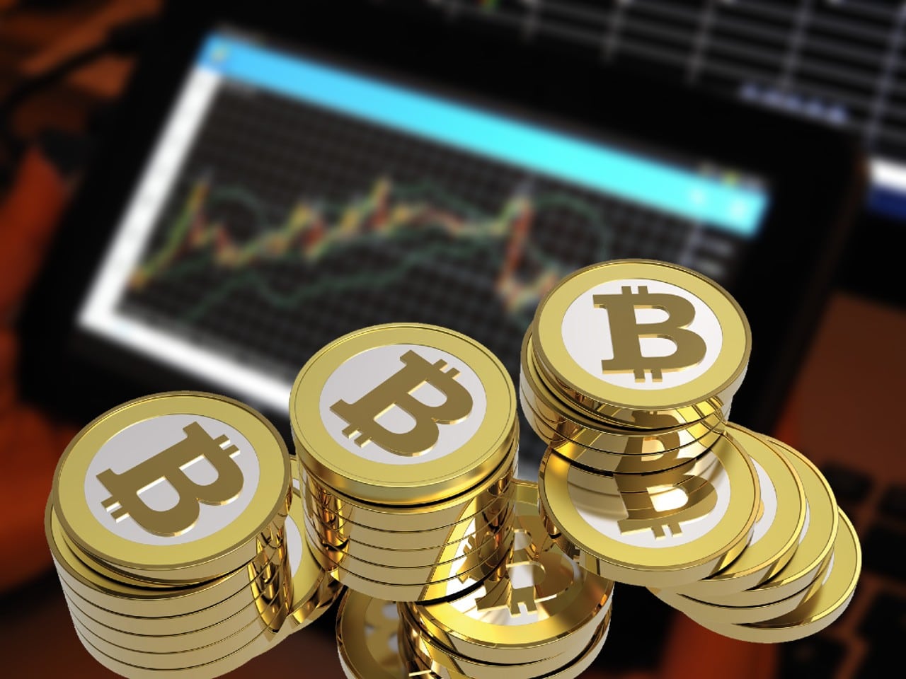 des pièces bitcoin (BTC) avec un graphique en chandelier en background