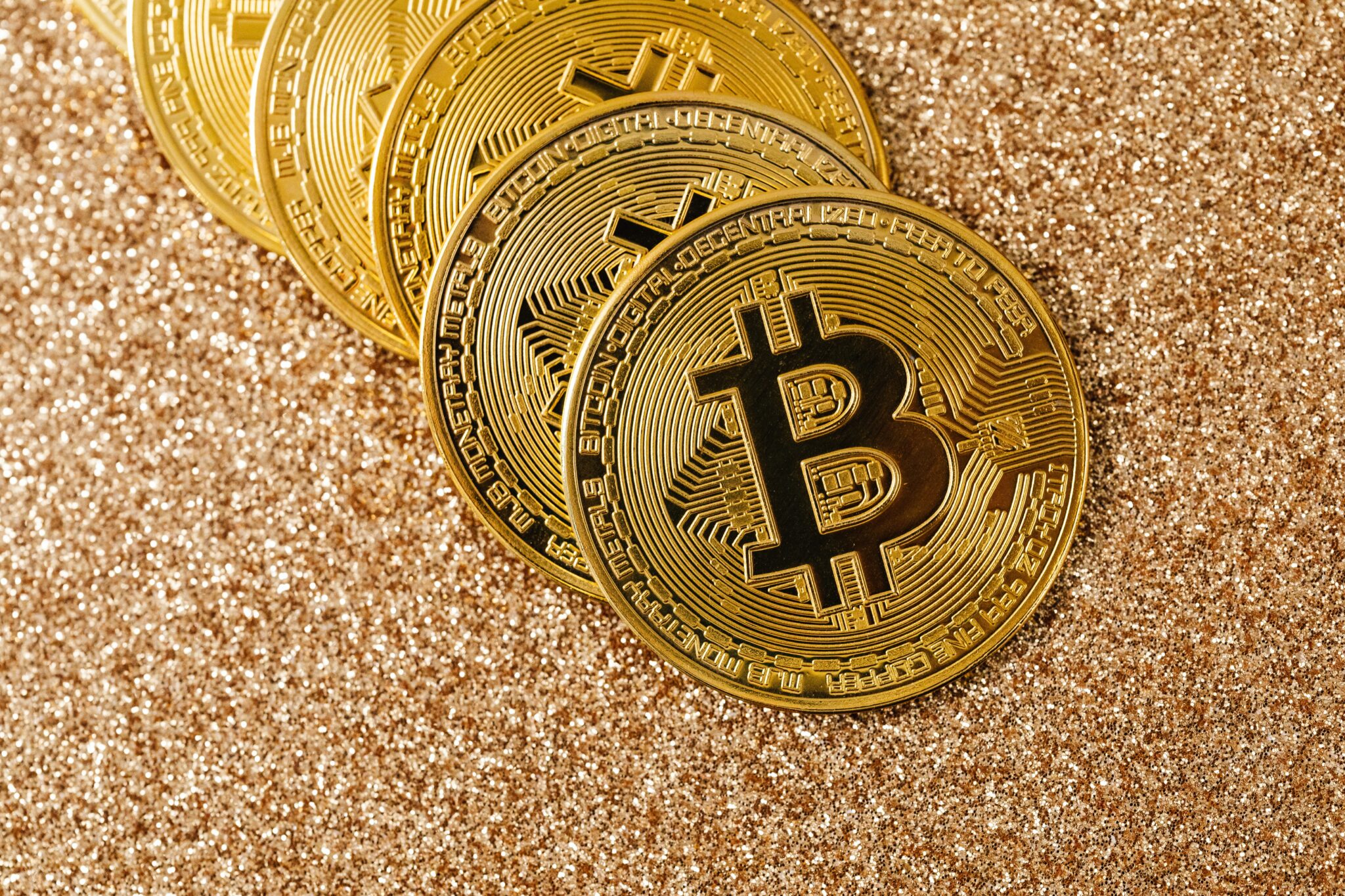 Des pièces de bitcoin posées sur du sable de mer
