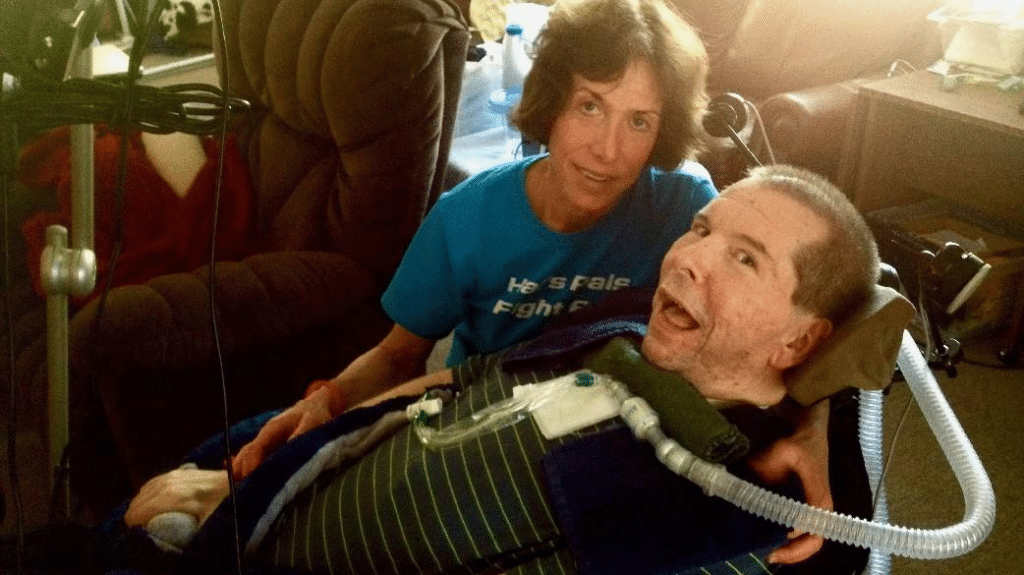hal finney en silla de ruedas sonriendo junto a su esposa Fran