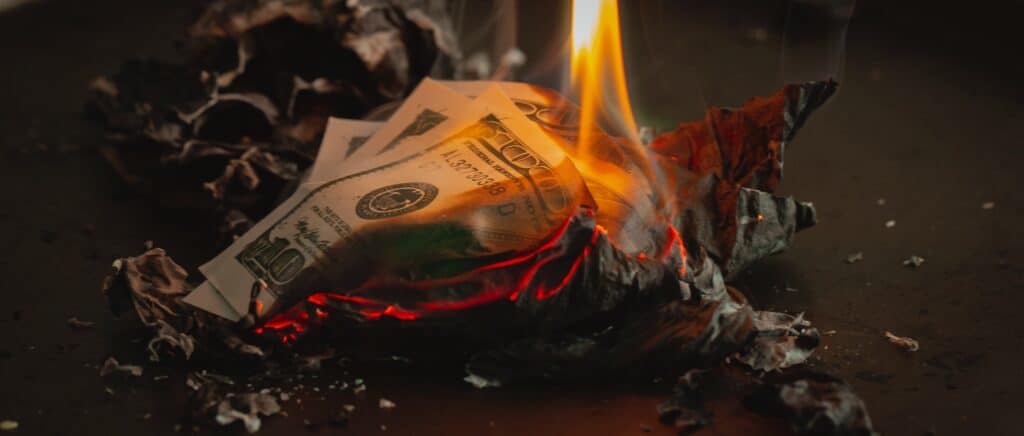 Un billet de banque qui brûle au sol.