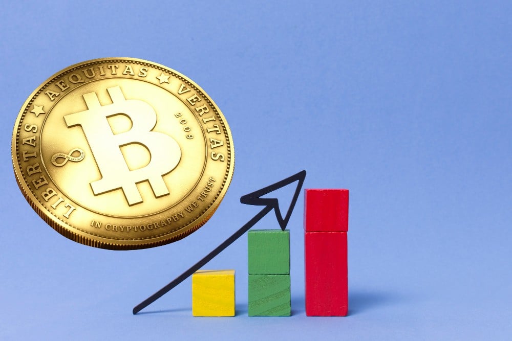 A bitcoin (BTC) coin with an arrow indicating a rise