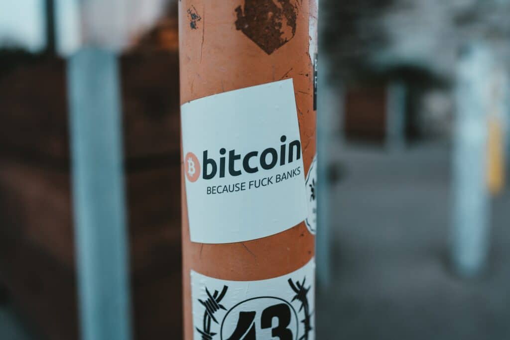 "Bitcoin because fucks banks", sticker sur un poteau dans la rue.