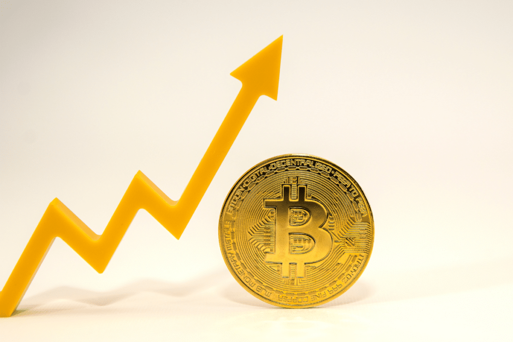 A bitcoin and an upward arrow