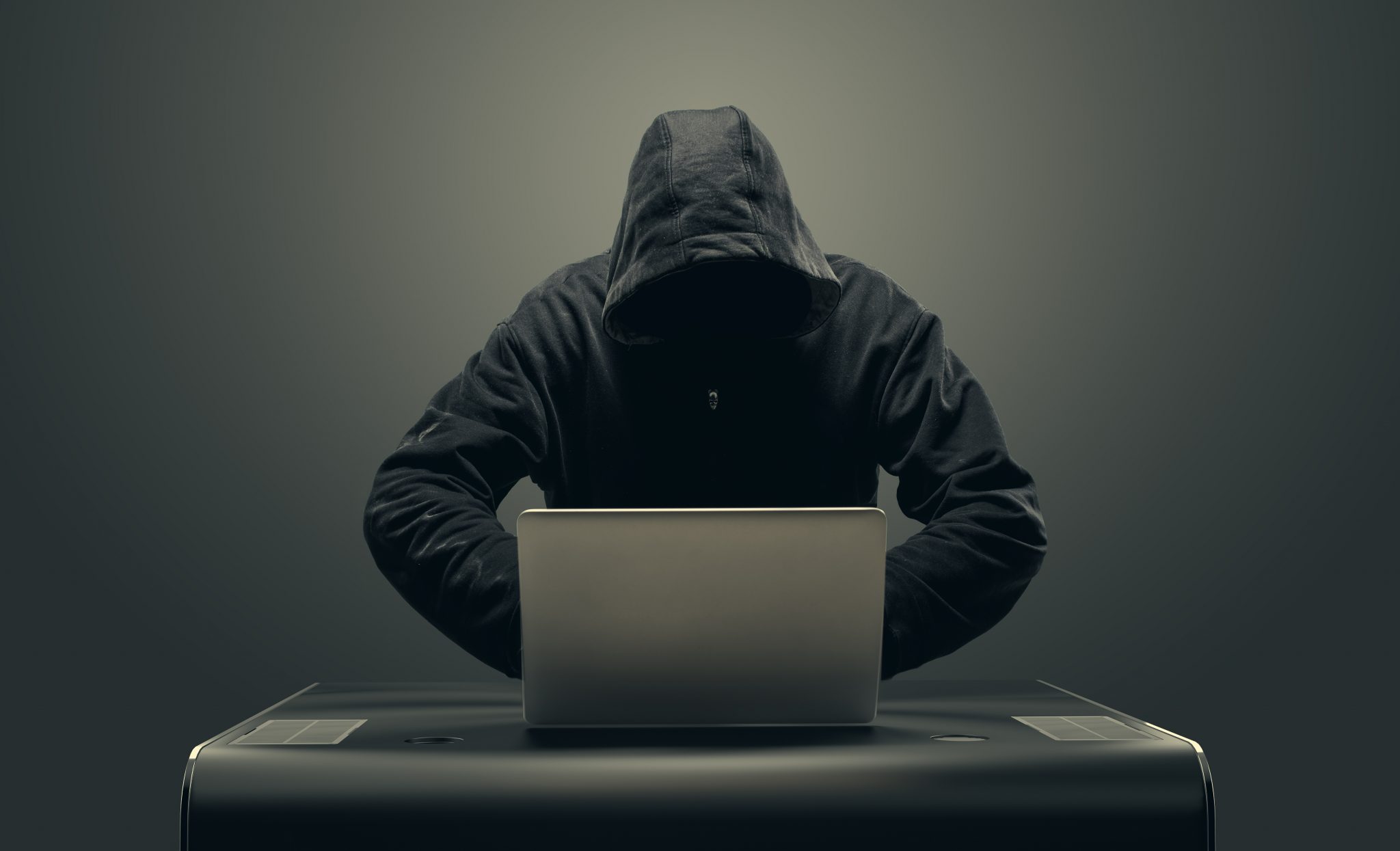 Hacker in mask by laptop