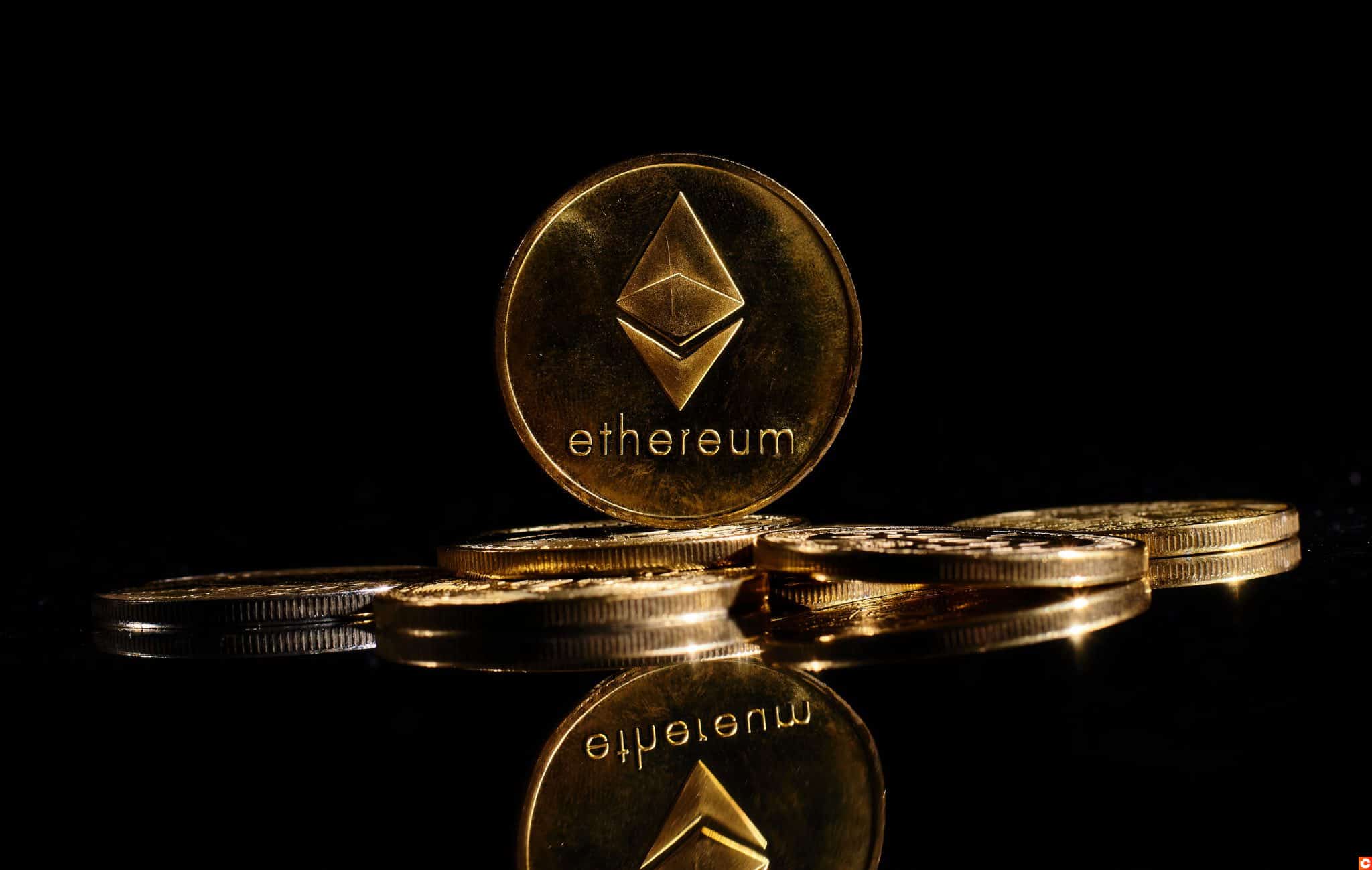 New cryptocurrency Ethereum ETH 2.0 on a top of bitcoin coins against black background. Closeup golden coin with Ether logo. A heap of decentralized digital currency. Crypto payment. Electronic money