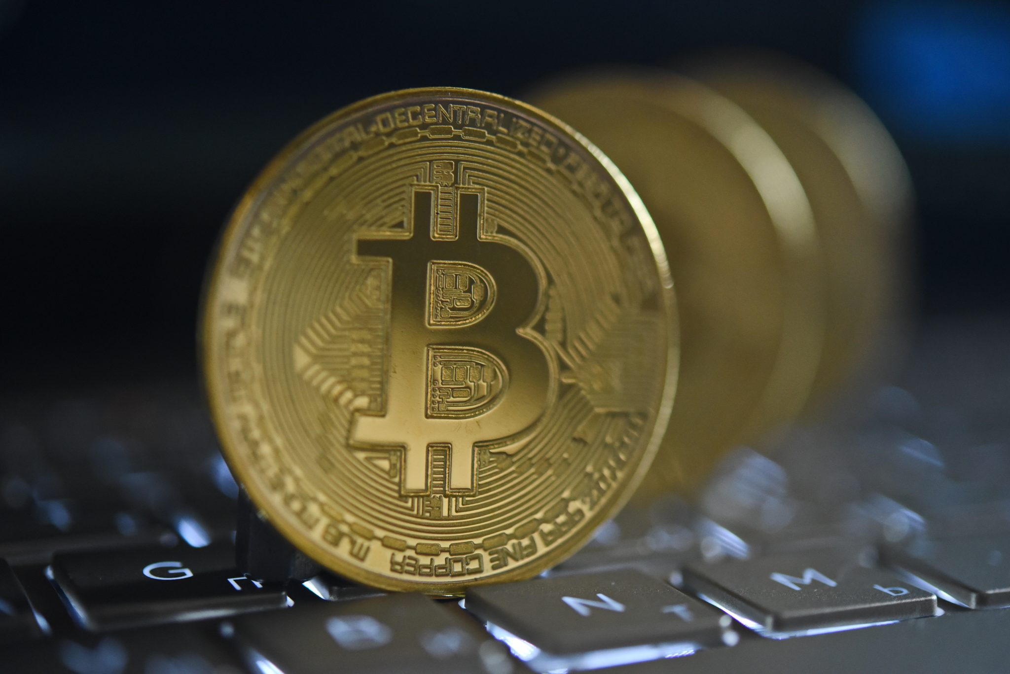 Almaty / Kazakhstan - 07.26.2019 : Metal coin on the laptop keyboard. The bitcoin symbol is an electronic payment system.