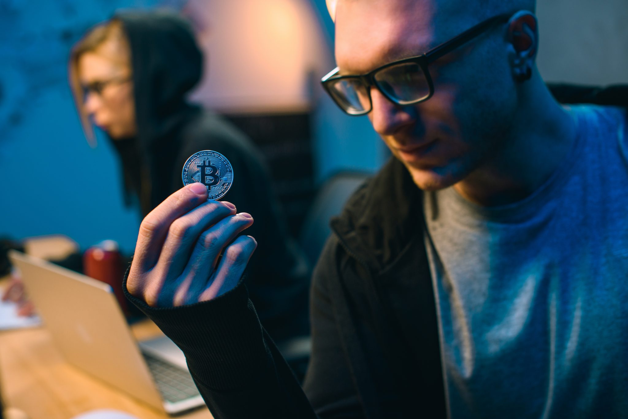 close-up shot of young handsome hackers holding bitcoin