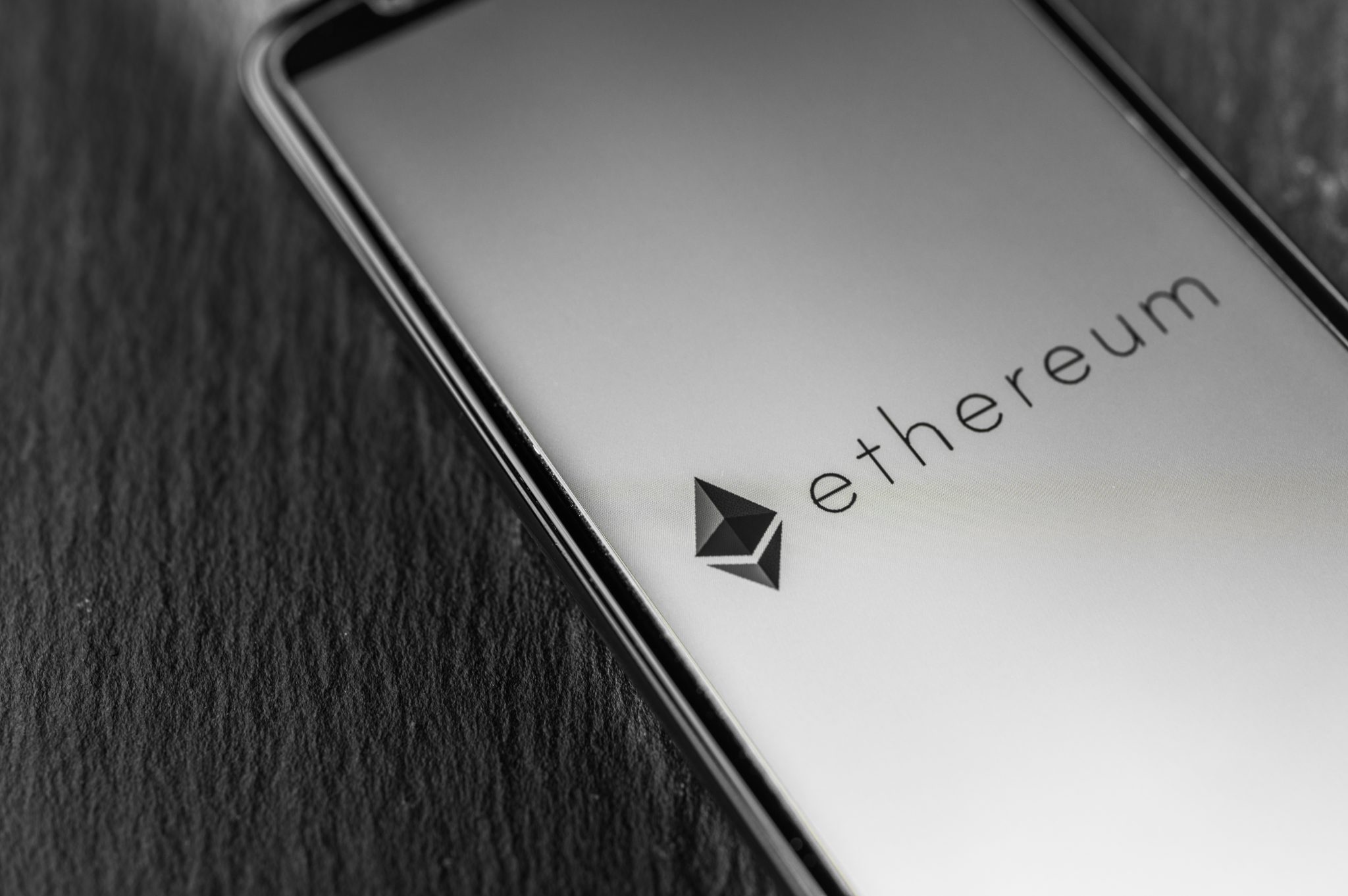 Logo of Ethereum blockchain money cryptocurrency on screen of smartphone.
