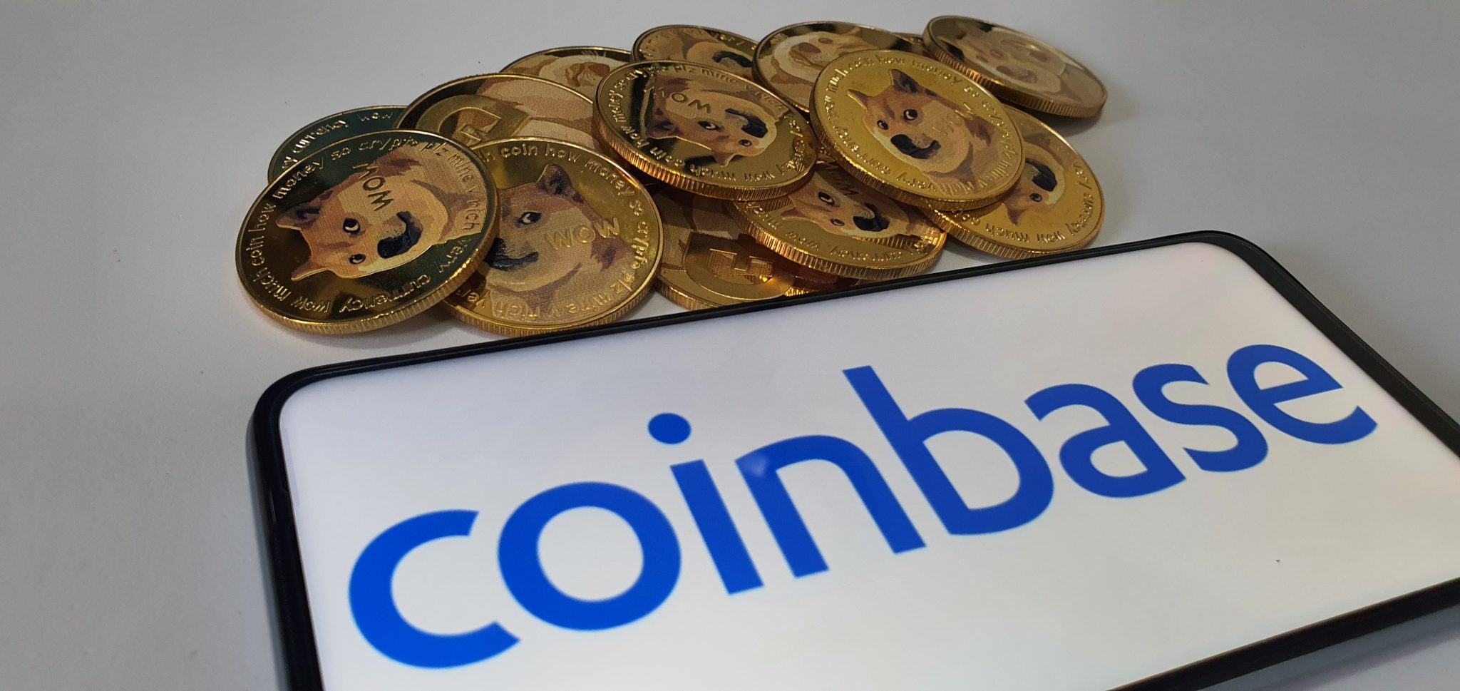 Kuching, Sarawak Malaysia - June 2, 2021: Macro view of gold color shiny coins with Dogecoin symbol and Coinbase background